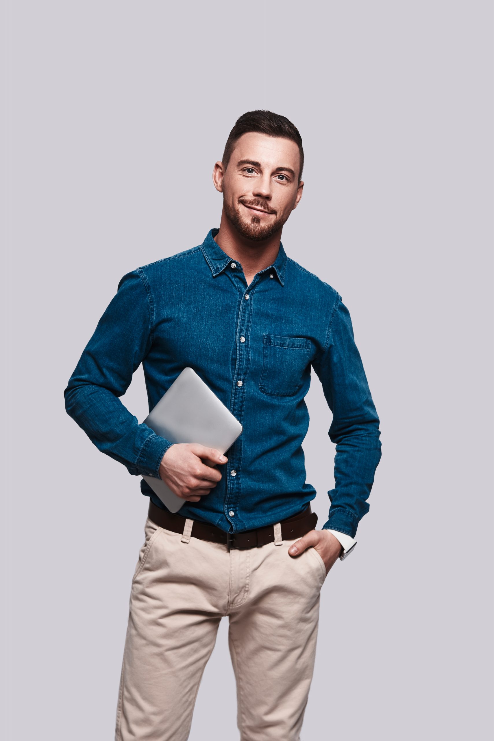 Confident businessmen. Good looking young man in smart casual wear looking at camera and smiling while standing against grey background